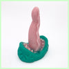 A venus fly trap inspired dildo with a green flower head, sharp looking teeth and a pink protruding tongue on a white background
