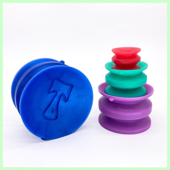 A stack of 3 double sided suction cups in different sizes and colours, with a larger blue suction cup on the left on its side