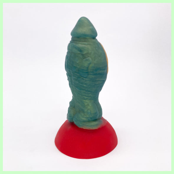Toad dildo rear view in green with large round gold belly, sitting on a red toadstool base